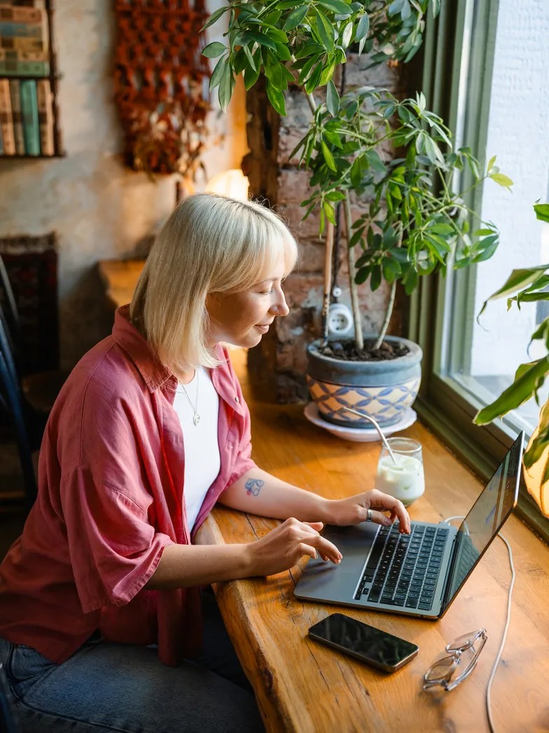 Freelancer working on a laptop at a cafe window, photo from the Wise Business website